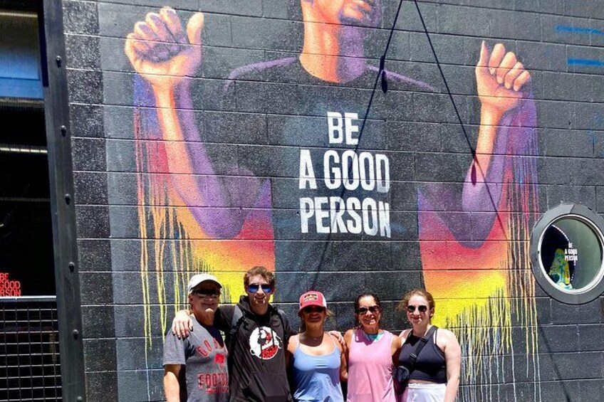 A mural with the text 'BE A GOOD PERSON' and a raised fist. 3