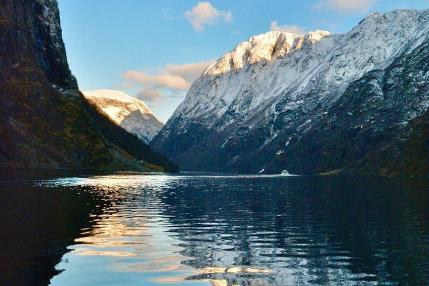A calm lake surrounded by snow-capped mountains. 1