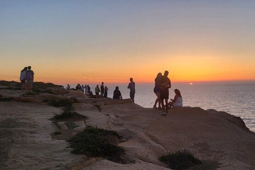 Un grupo de personas en la playa al atardecer. 4