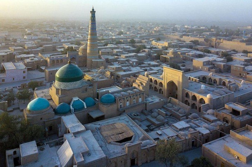 A cityscape with domed buildings and a prominent minaret. 5