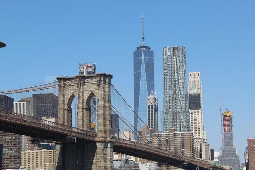The Brooklyn Bridge, One World Trade Center, and several other skyscrapers in the New York City skyline. 5