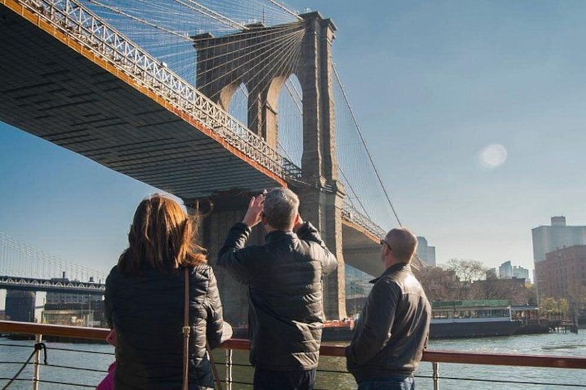 People taking a photo of the Brooklyn Bridge. 2