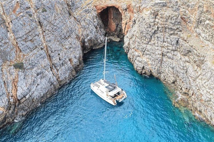 A boat anchored in a narrow waterway between rocky cliffs. 4