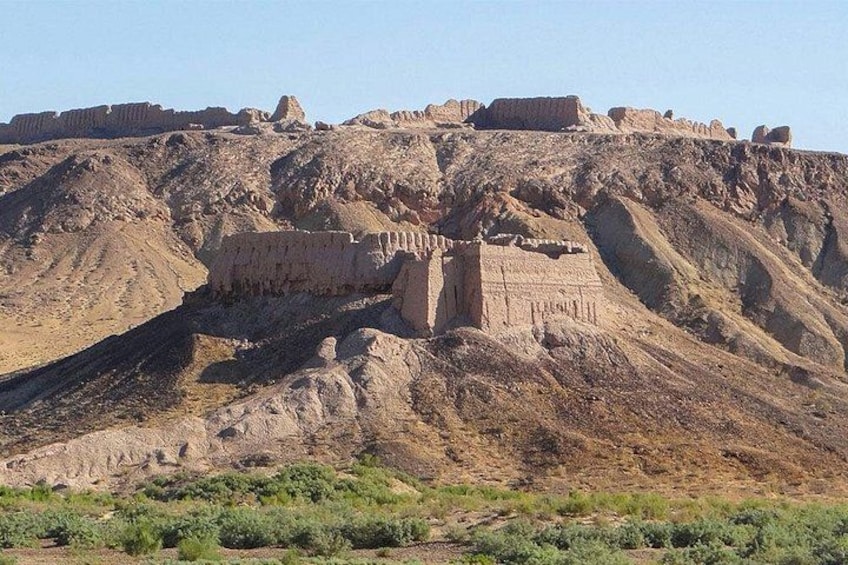A desert landscape with ancient ruins on a hill. 2
