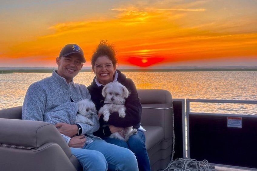 A couple on a boat with a sunset in the background. 2