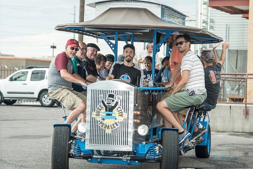 A group of people riding a blue vintage car with a canopy. 2