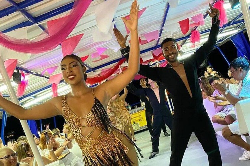 A person in a leopard print dress dancing, another in black, and a crowd watching. 1