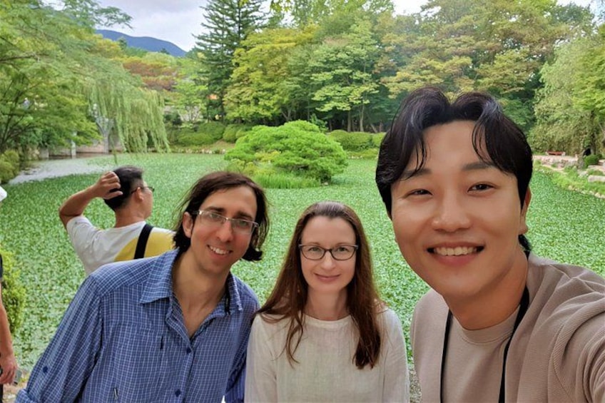 Three people in a garden with greenery and a path. 4