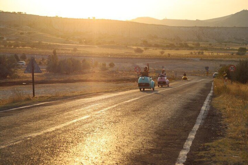 Una carretera rural con autos antiguos y una señal de límite de velocidad. 3