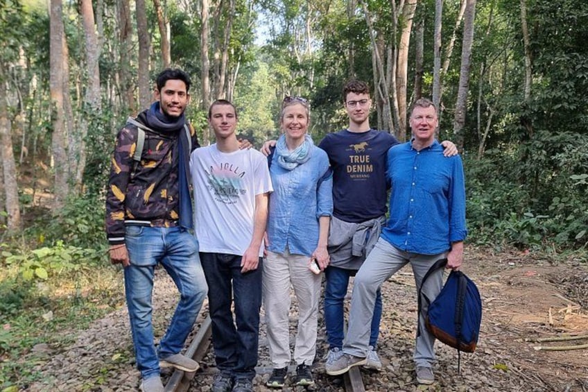 A group of people standing in a forested area with trees and underbrush. 2