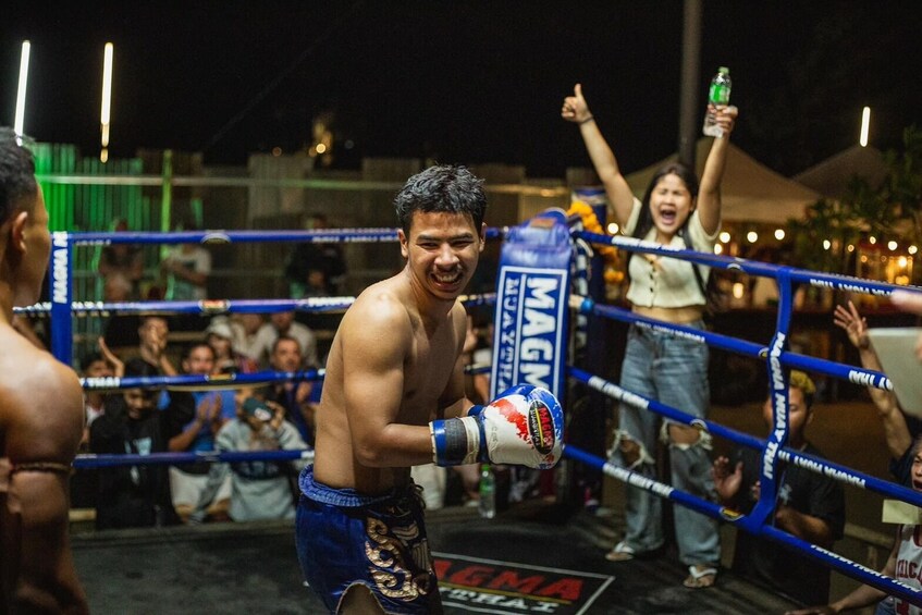 Un boxeador en el ring, con cuerdas azules y un público en el fondo. 4