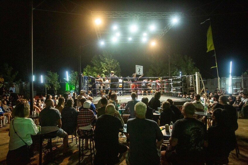 Un combate de boxeo al aire libre con una multitud de espectadores. 5