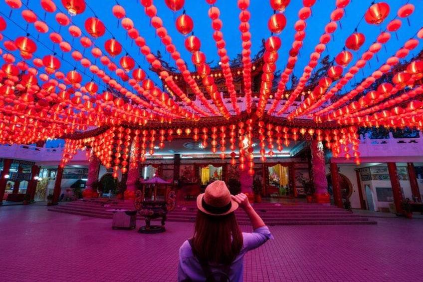 Una mujer fotografiando un edificio con faroles rojos. 2