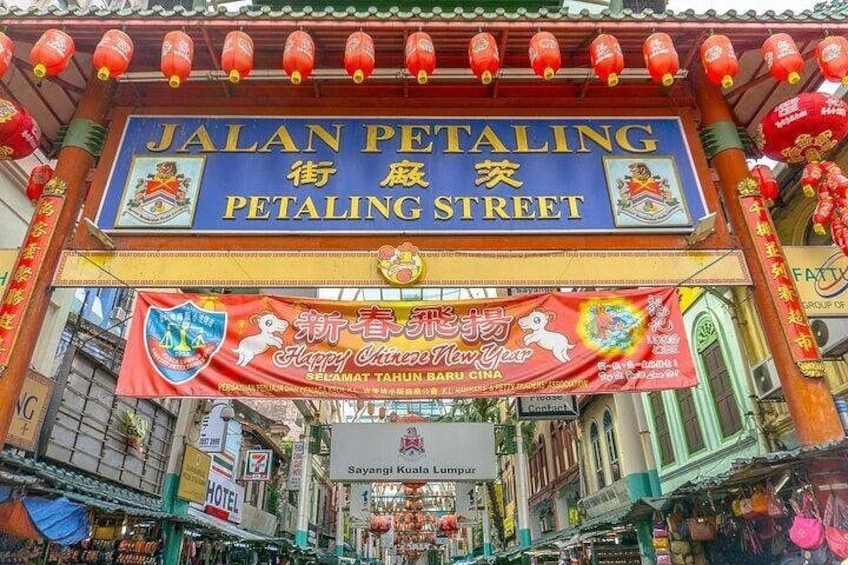 Una señal de calle para Jalan Petaling Street con decoraciones festivas y un cartel por el Año Nuevo Chino. 5