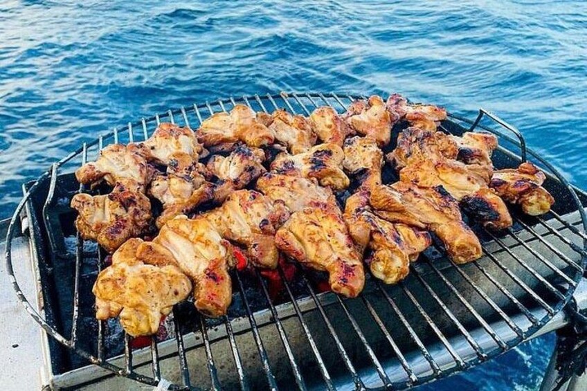Una parrilla con brochetas de pollo sobre el agua. 3
