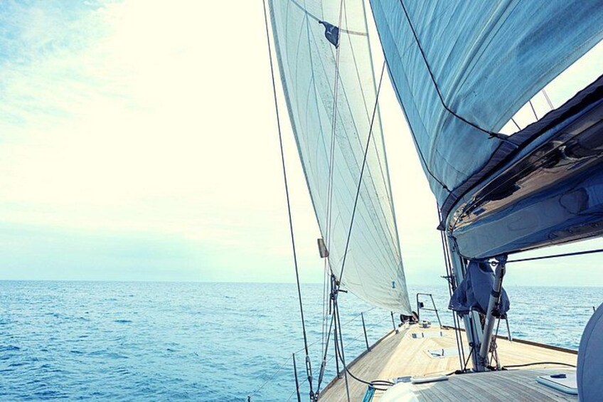 Un velero con velas desplegadas navegando sobre un mar tranquilo. 4