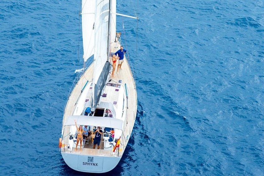 Un velero con el nombre 'SPHYNX' en su proa, navegando sobre aguas azules. 2
