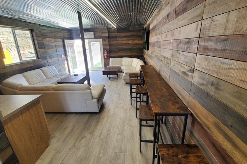 A modern interior with a wooden wall, a sofa, and a long table. 4