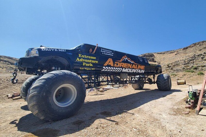 A large off-road vehicle with 'Extreme Adventure Park' and 'Adrenaline Mountain' branding parked on a dirt surface. 2