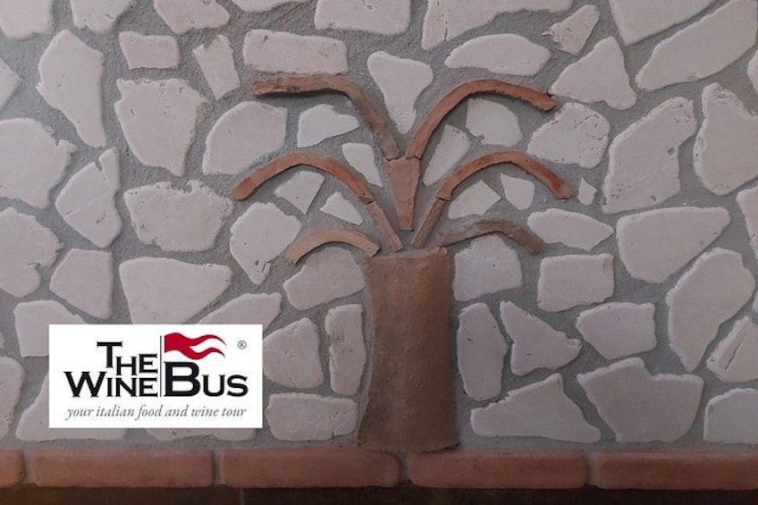 A decorative wall with a logo for 'The Wine Bus' and a stylized tree. 4