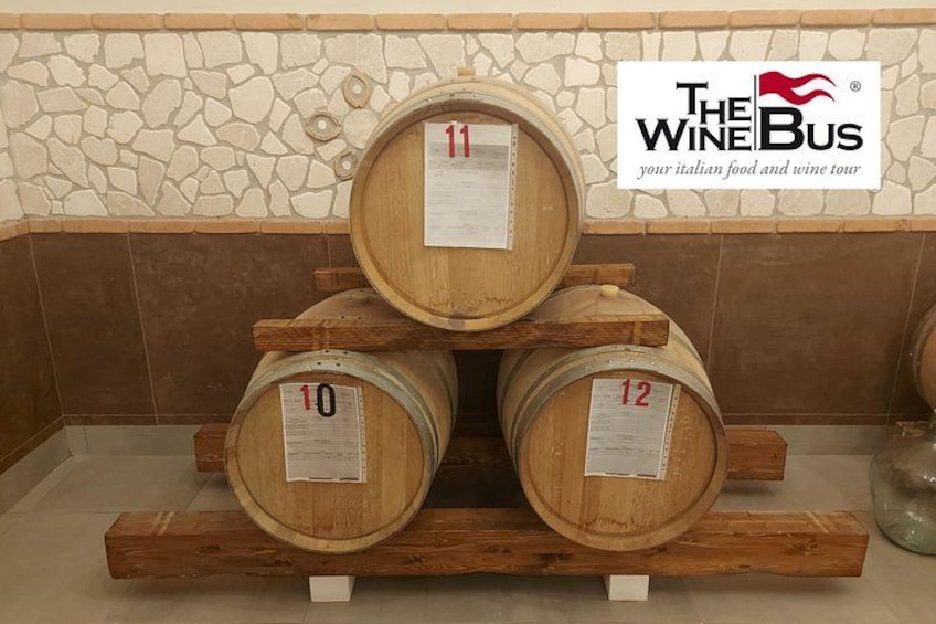Wooden wine barrels stacked on a wooden rack with labels 10, 11, and 12. 3