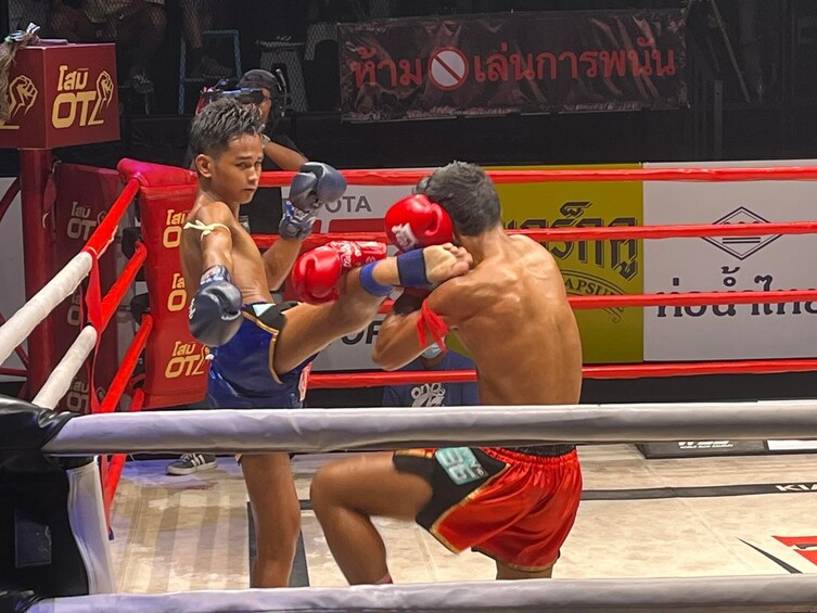 To boksere i en ring, den ene i blå shorts og den anden i røde shorts, kæmper. 2