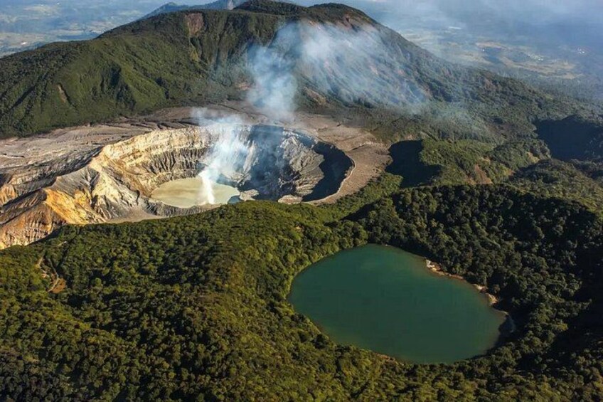 A volcanic crater with a lake, surrounded by forested hills. 1