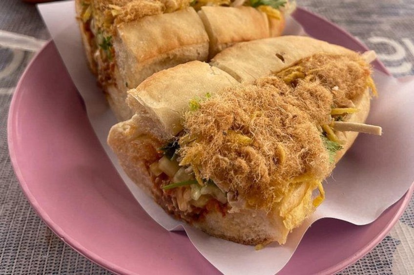 Ein Sandwich mit knuspriger Kruste auf einem rosa Teller. 1