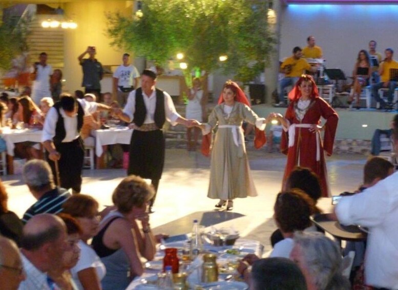 Representación medieval con participantes disfrazados, un público observando y mesas preparadas para una comida. 3