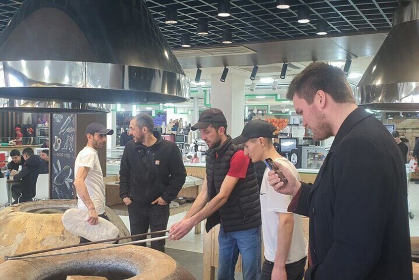 People around a large cooking pot, possibly preparing food. 4