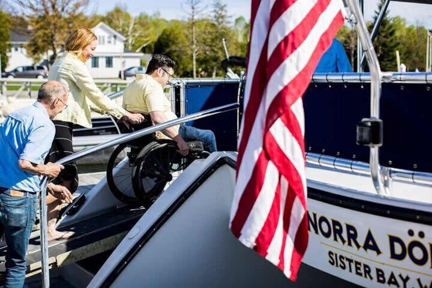 A boat with people boarding, an American flag, and a sign reading 'NORRA DOÖ Sister Bay.' 2