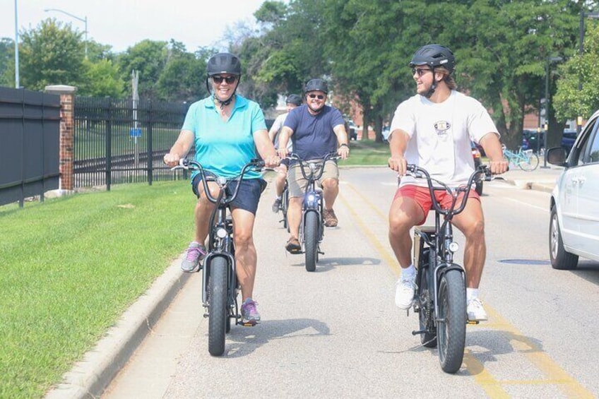 Three people riding bicycles on a paved path. 3