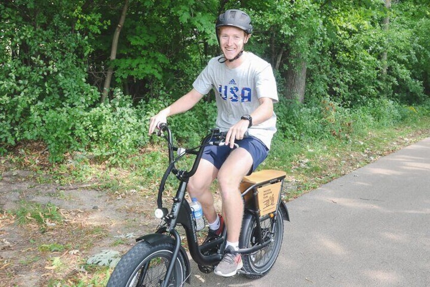 A person riding a bicycle with a box attached to the back. 2