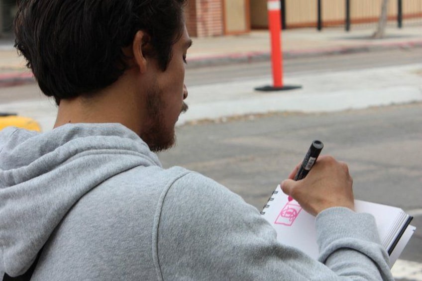 Una persona escribiendo en un cuaderno con un bolígrafo. 4