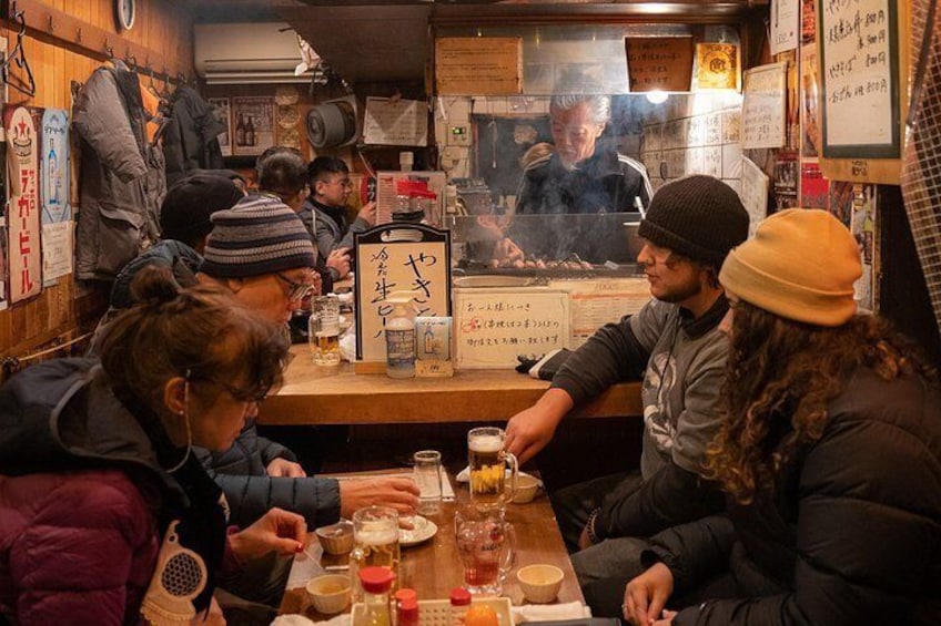 Un grupo de personas cenando en un restaurante con barra y carta. 5