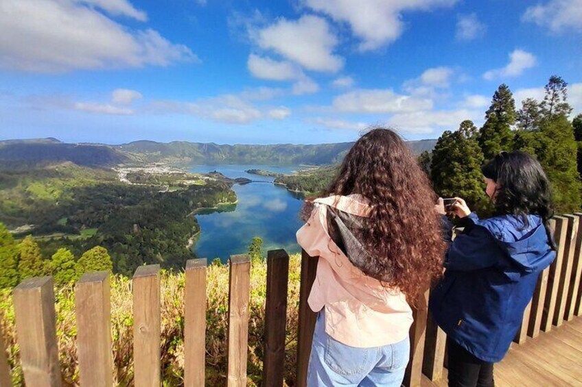 Dos personas fotografiando un lago rodeado de colinas. 3