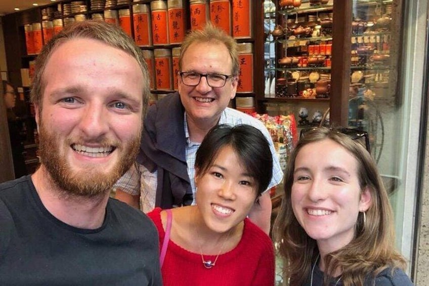 Un groupe de personnes se trouve dans un espace intérieur, devant des étagères remplies de divers objets. 3