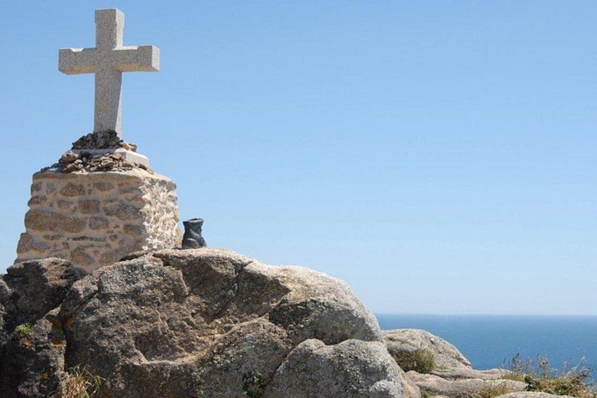 A stone cross on a rocky outcrop with a clear sky in the background. 5