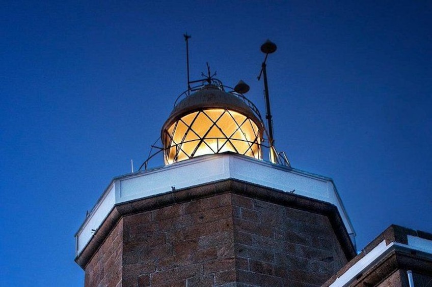 A brick building with a lit dome and antennas. 2