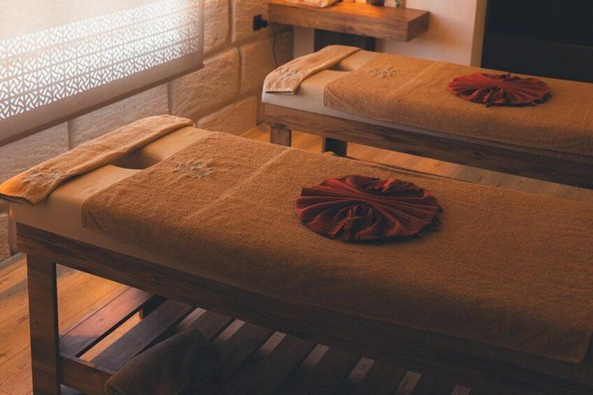 A wooden bench with a towel and a red cloth on it. 3