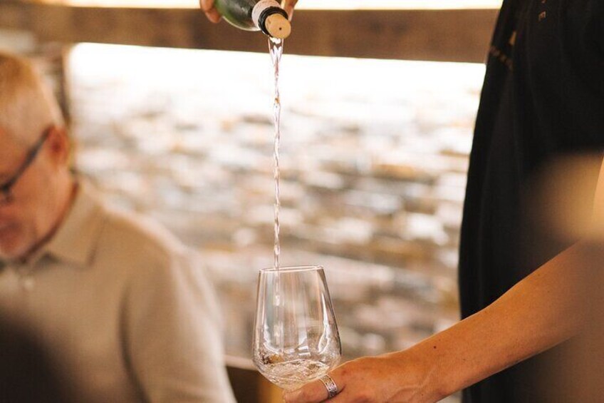 A person pouring liquid from a bottle into a glass. 4
