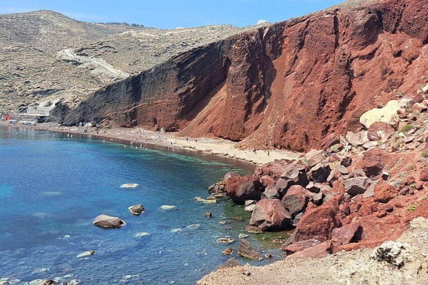 Un paysage côtier caractérisé par une eau bleue et limpide, des falaises rocheuses et une plage de sable. 4