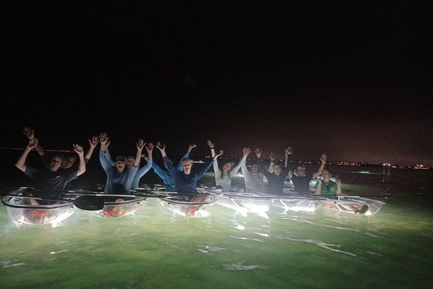 People in transparent tubes on a grassy field at night. 4