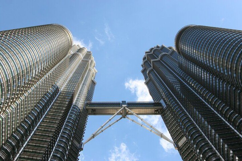A pair of tall, cylindrical skyscrapers with a bridge connecting them. 3