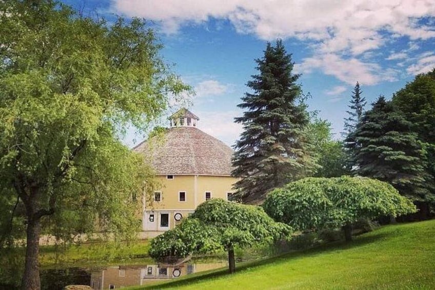 A yellow building with a dome roof, surrounded by trees and a grassy area. 3