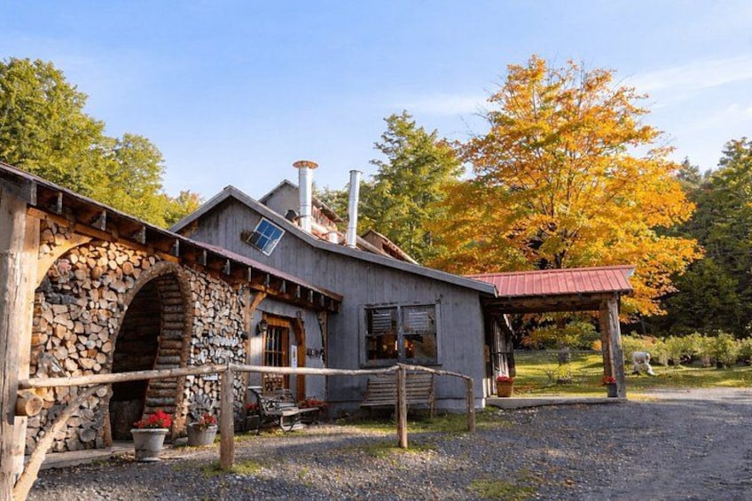 A rustic building with a stone archway, a wooden porch, and a red-roofed structure. 2
