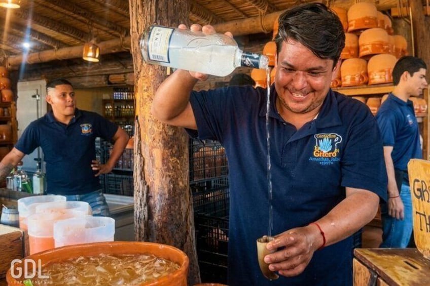 Una persona vertiendo un líquido de una botella a un vaso. 5