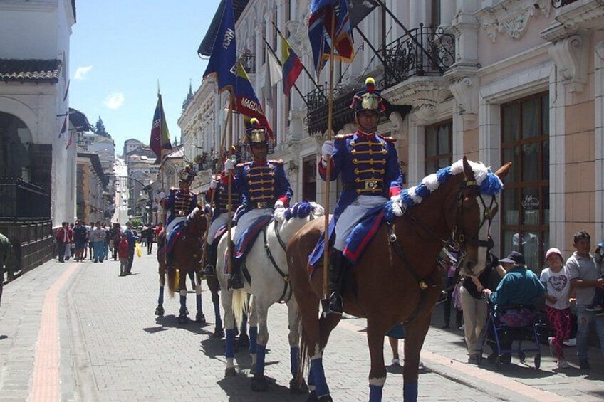 En parade med uniformerede livgarden, brostensbelagte gade og historiske bygninger. 5