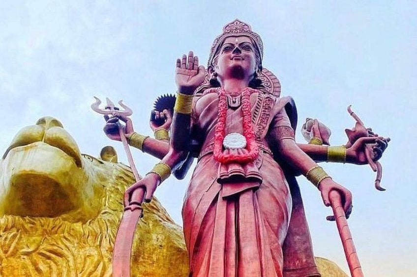 A multi-armed deity statue with a trident, surrounded by golden structures. 2