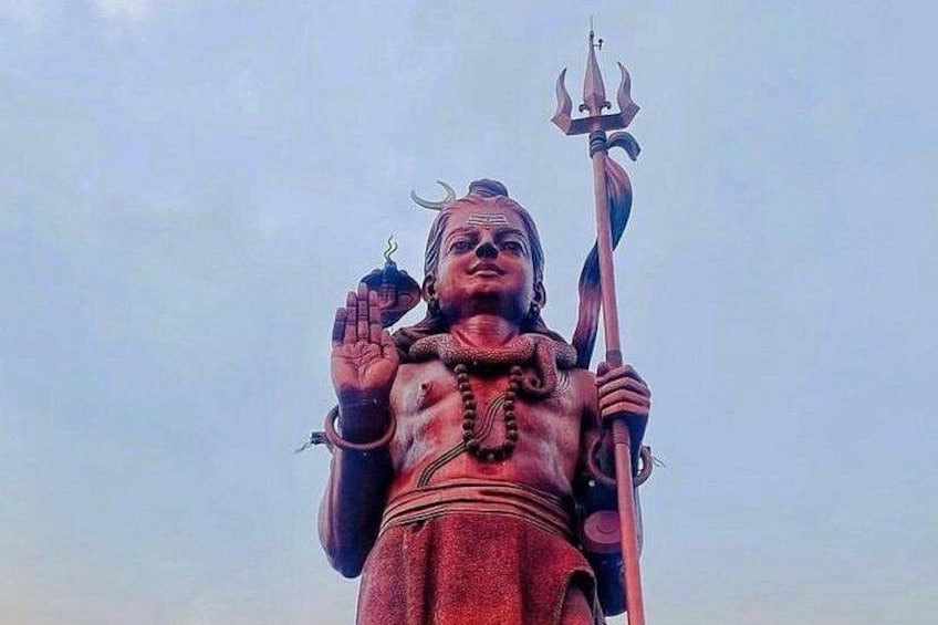 A statue of a deity holding a trident and a drum, with a crescent moon on the head. 3